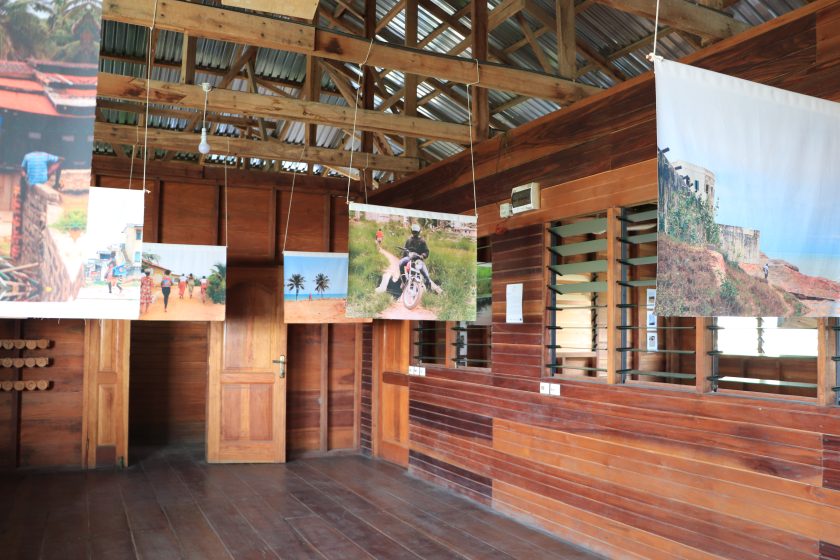 A wooden room with banners hanging from the ceiling each with a different photo on them