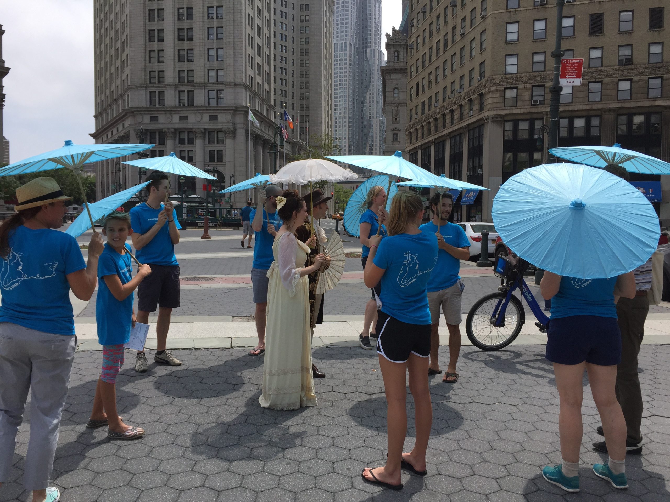 A group of people each with a blue paper umbrella standing in a group