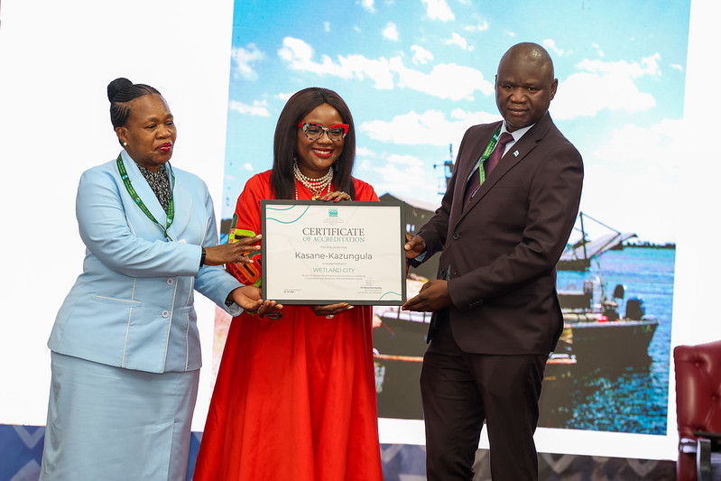 A person accepting a framed certificate