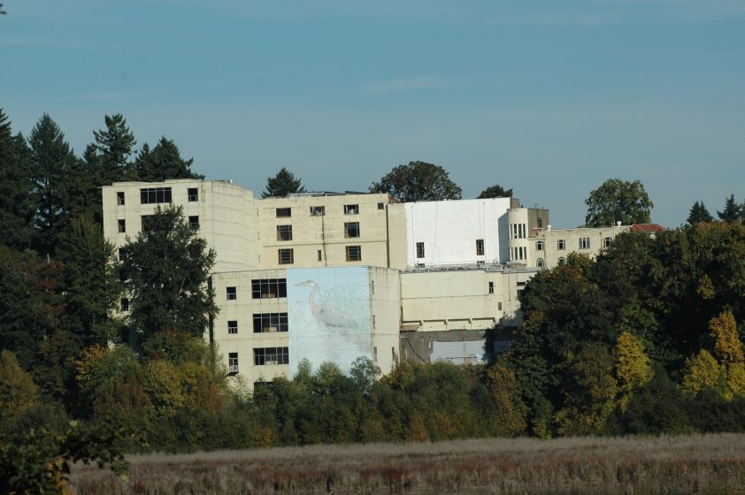 A tan building surrounded by trees