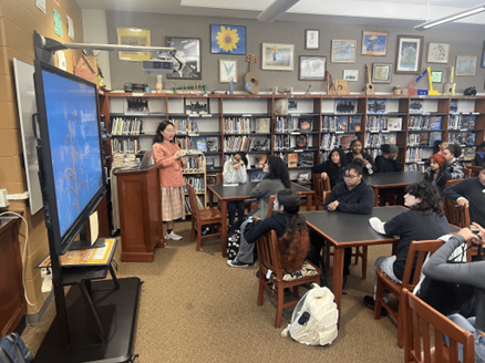 A classroom of students watching the teacher