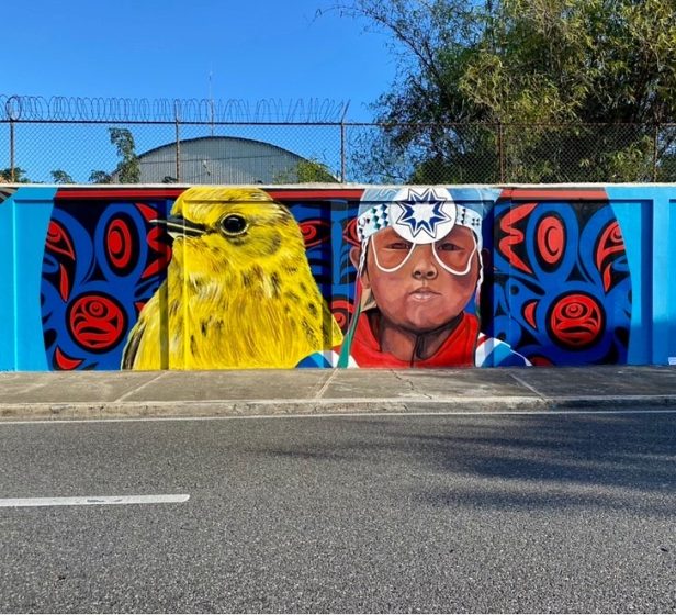 A mural of a child's face and a yellow bird 