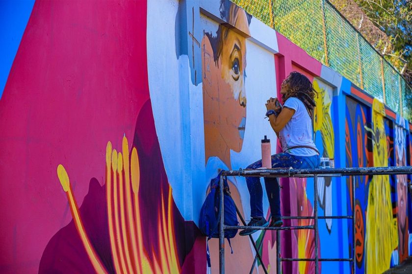 A person painting a colorful mural