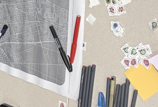 A grey map, stickers, and markers on a table