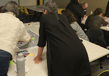 A group of people sitting and standing at tables