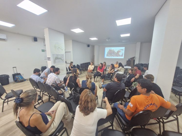 A group of people sitting in a room watching a presentation