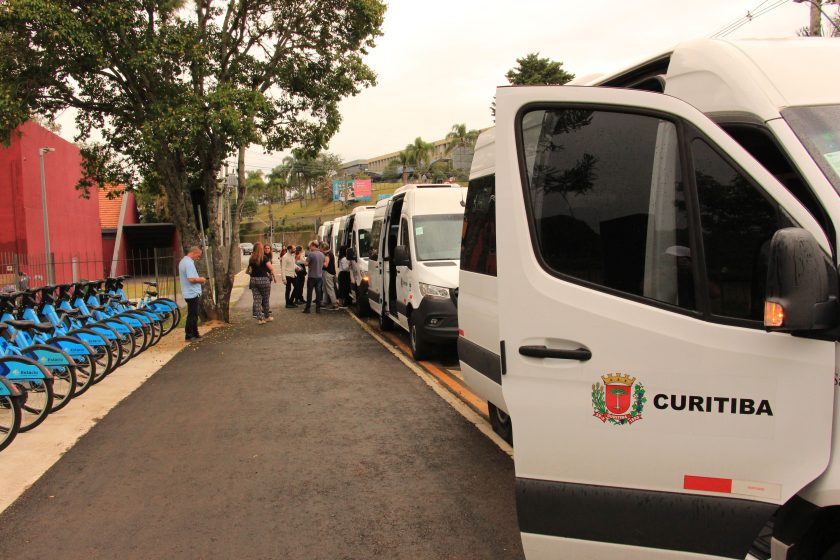 A group of white vans parked on the side of a road