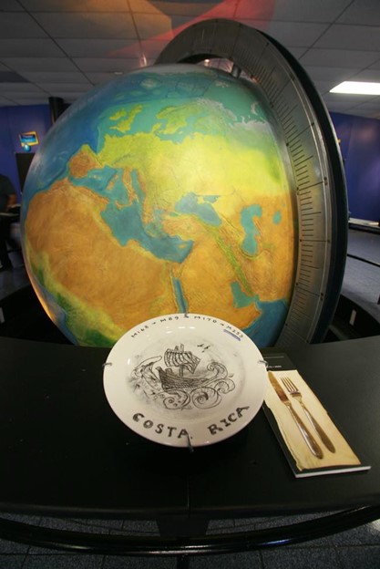 A plate and fork next to a globe