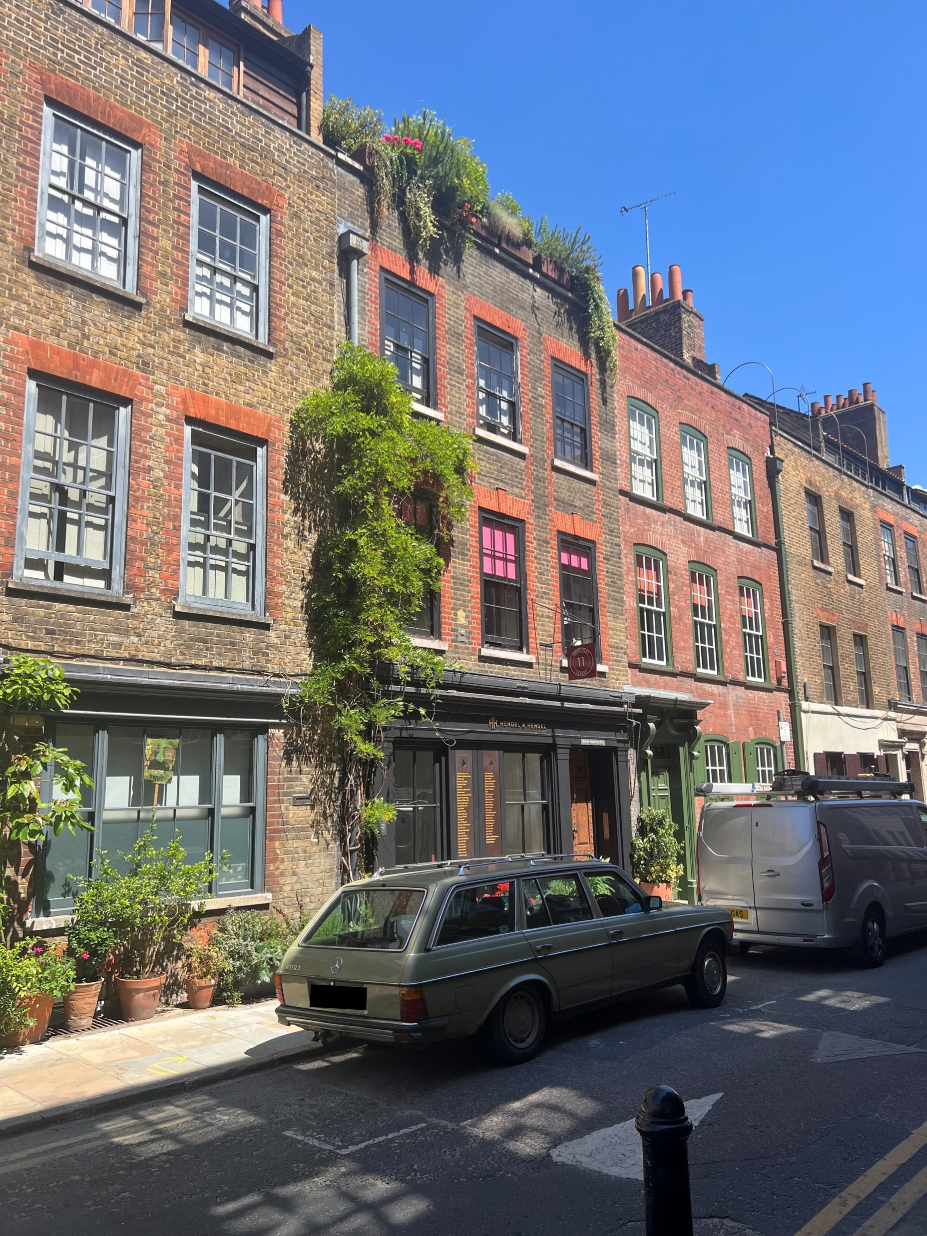A multistory building with plants growing up the sides