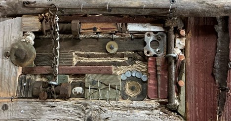 A wooden box full of old tools and mechanical parts