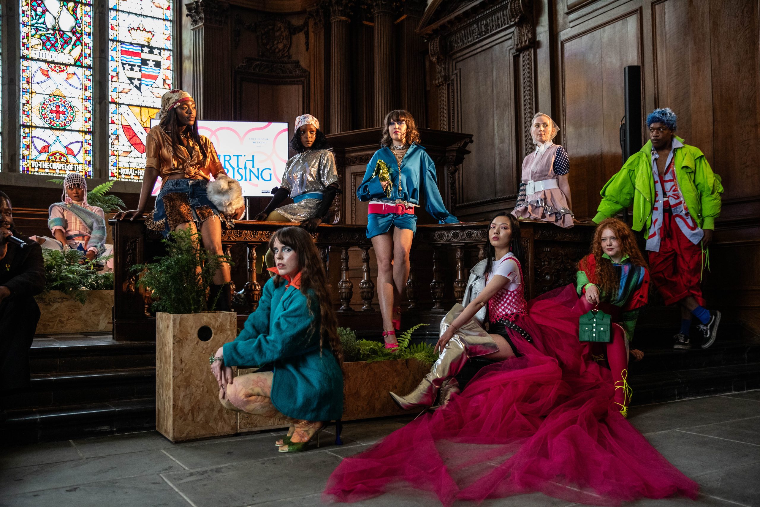 A group of people performing a fashion show with brightly colored clothing