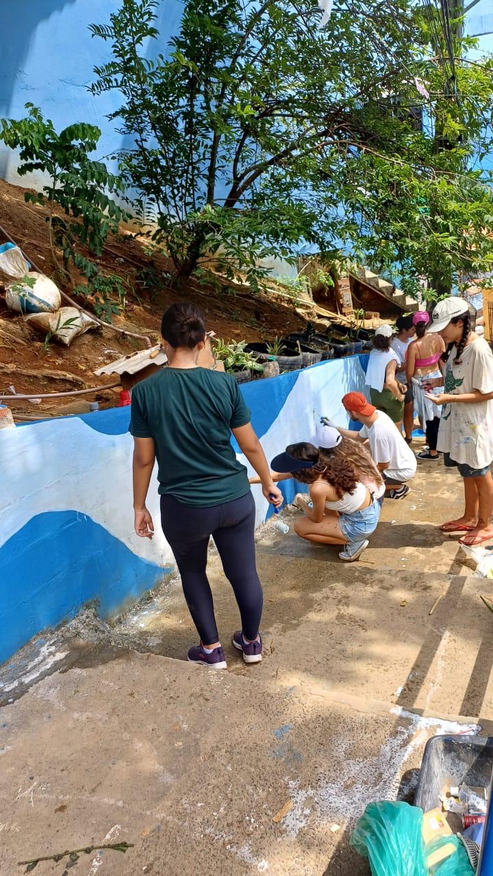 A group of people painting a mural on a concrete wall